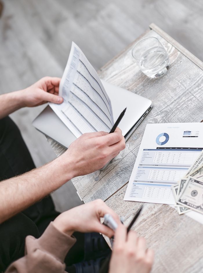 Two professionals reviewing financial documents with charts, fostering collaboration.